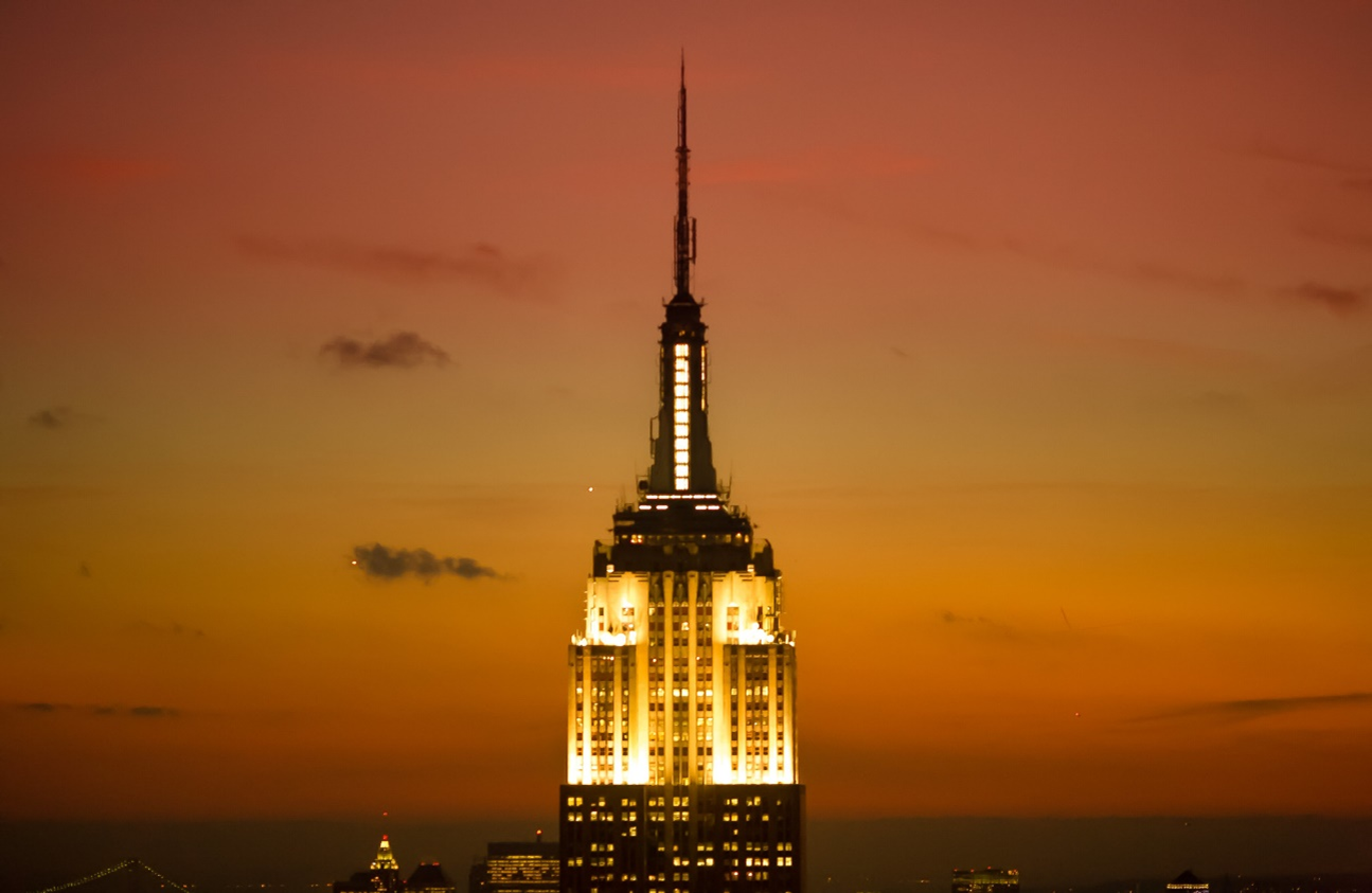 The photo of the top of Empire State Building at sunset