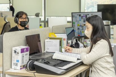 Jeong Byoung-zoo and Chung Soo-yon, senior sound designers at LG UX Governance Team working at the office with their headsets on