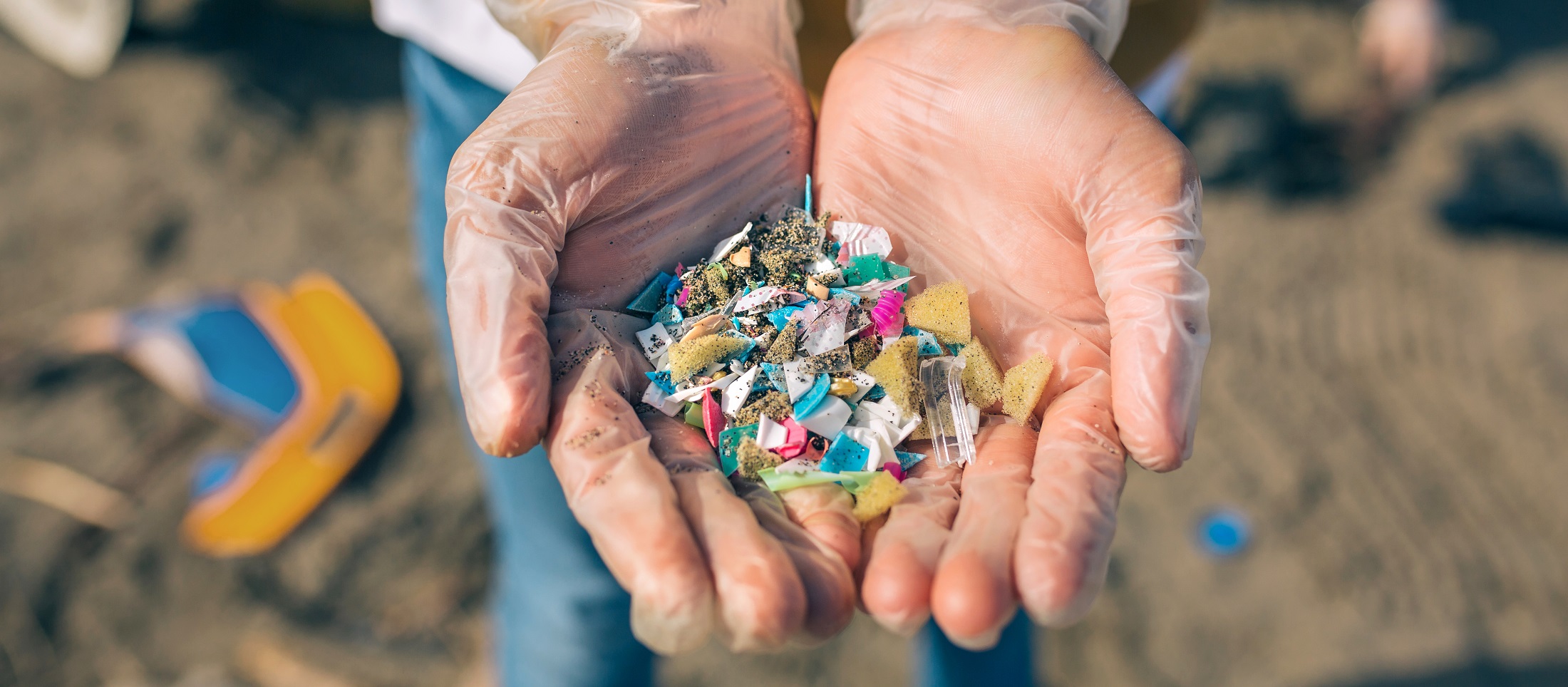 A human hand holding a bunch of microplastics
