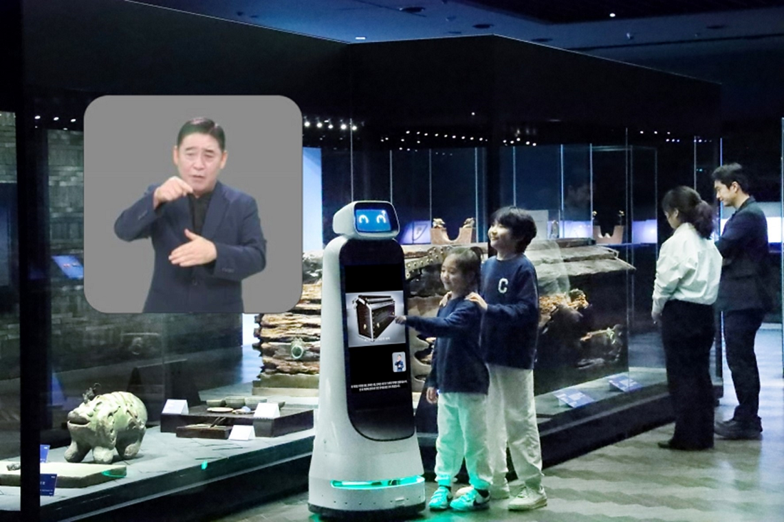 A photo of LG CLOi robot explaining details about the exhibition to two kids at a museum