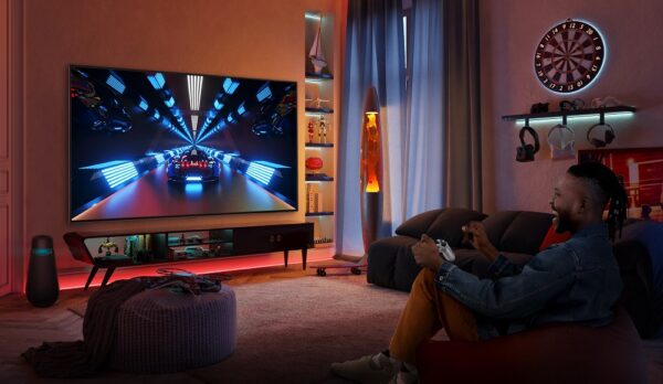A gamer playing a racing game in a dimly lit living room via cloud gaming