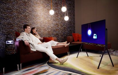 A couple sitting on a sofa while watching an animation movie on LG OLED Objet Collection Posé