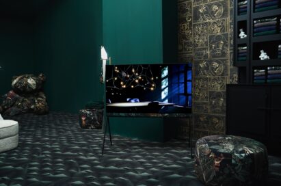 LG OLED Objet Collection Posé in the center of a green-themed showroom designed by Dutch brand Moooi, as it displays a table under lights