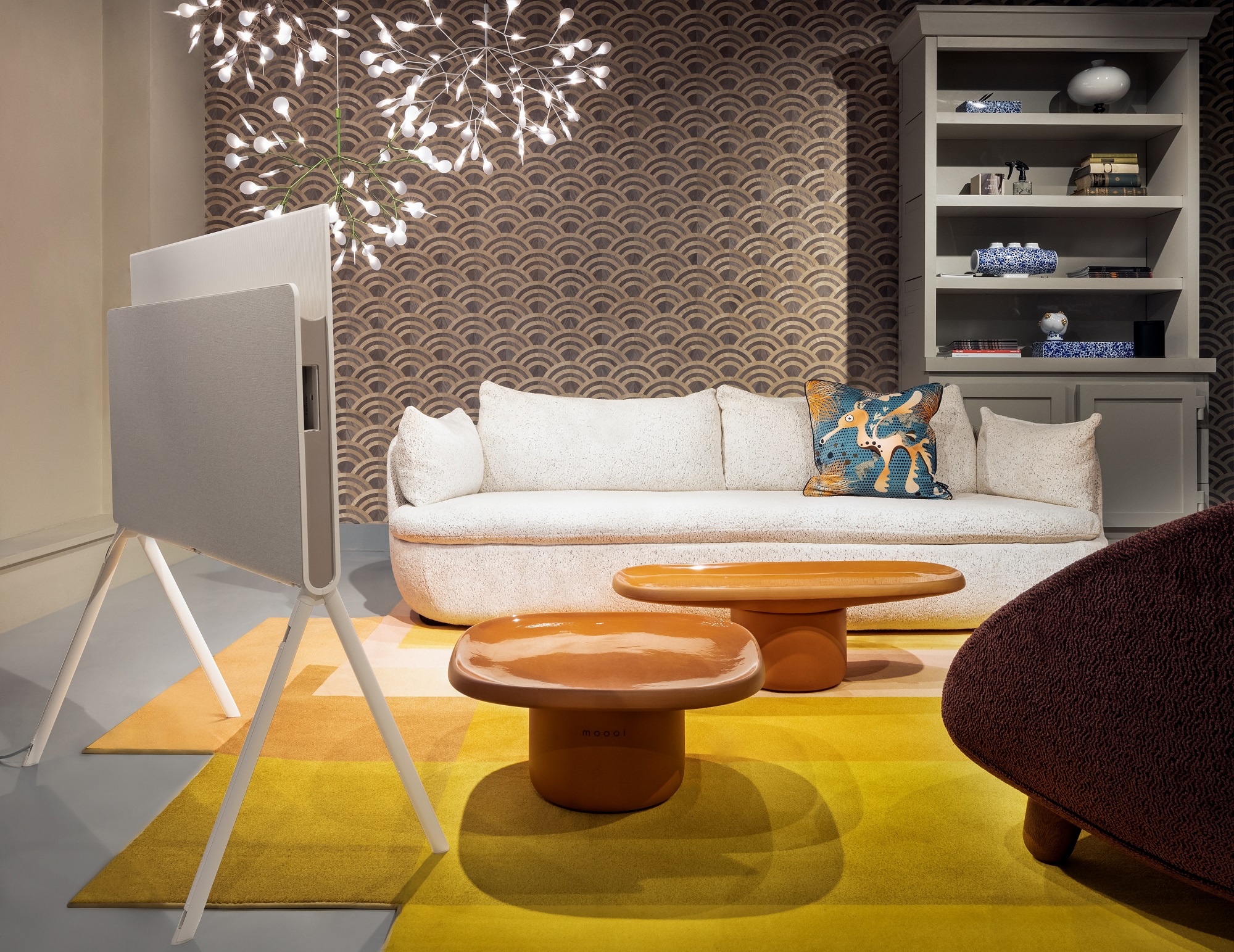 LG OLED Objet Collection Posé in a bright living room with a white sofa, brown tables and yellow carpet