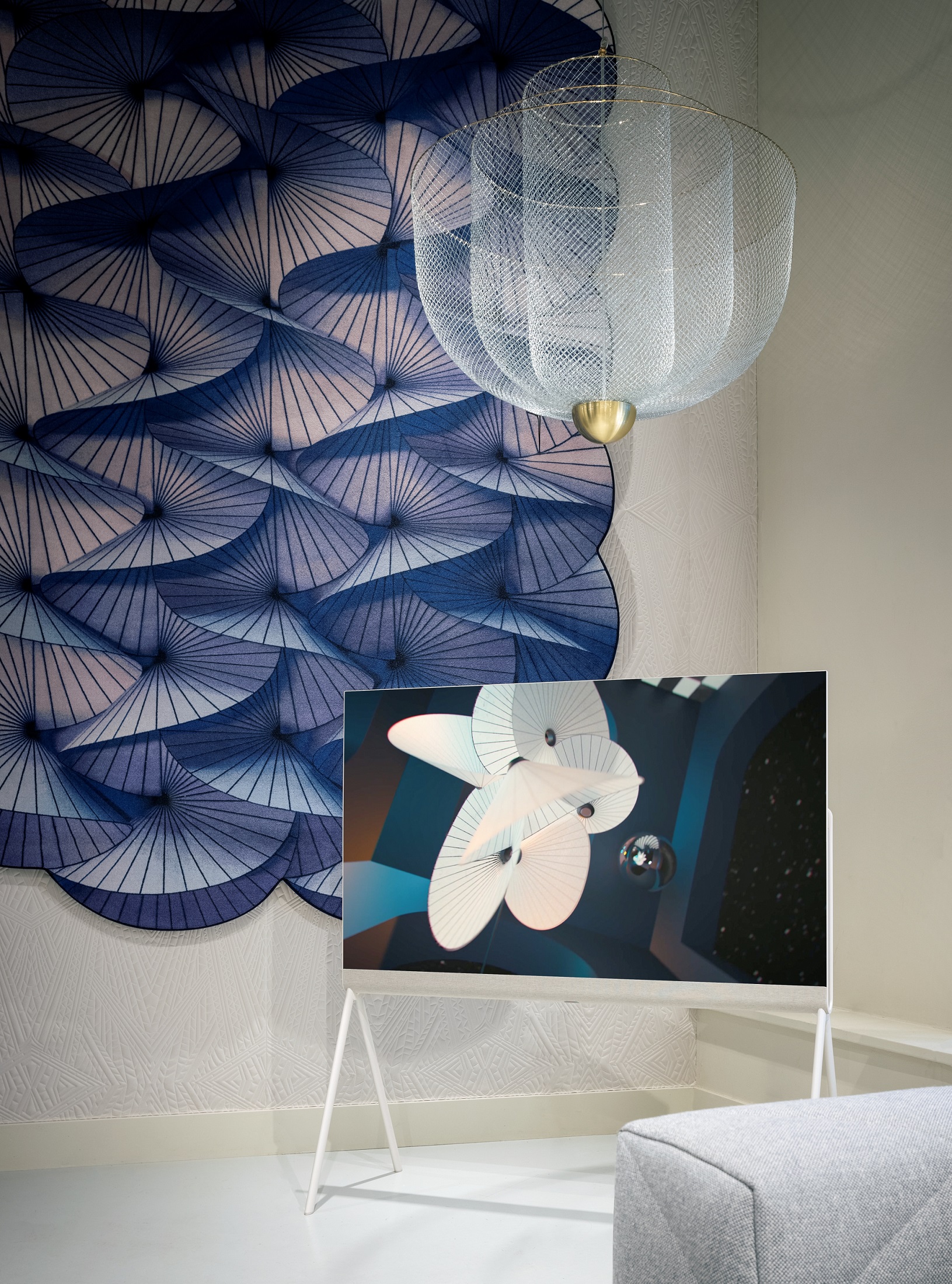 LG OLED Objet Collection Posé displaying artwork in a room with an elegant chandelier and blue-themed wall artwork