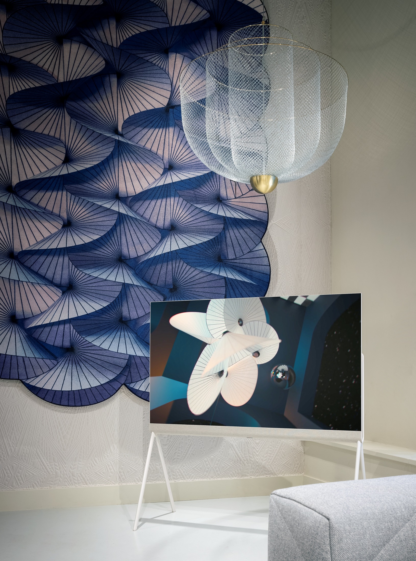 LG OLED Objet Collection Posé displaying artwork in a room with an elegant chandelier and blue-themed wall artwork