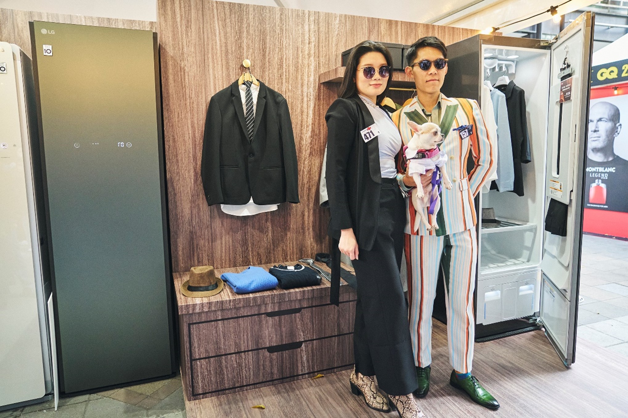 Two visitors posing in front of LG Styler at LG booth during GQ Suit Walk