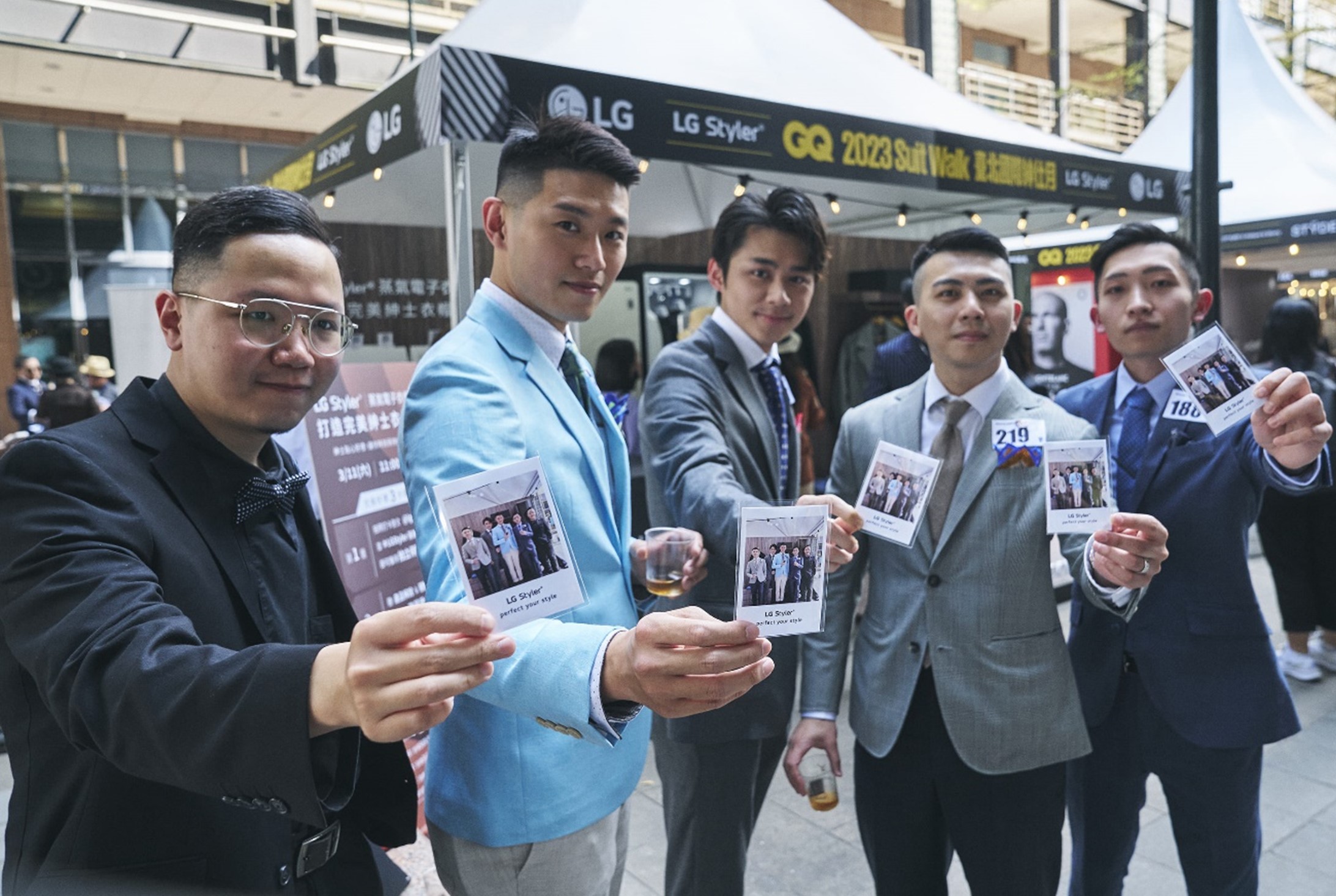 Five men posing with polaroid photos in their hands which was taken as an event at LG booth