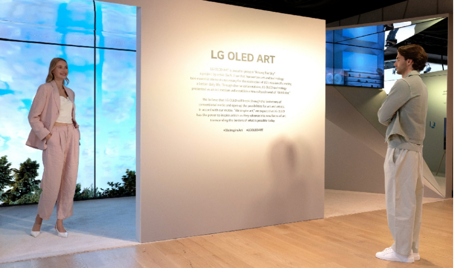 A man and a woman reading a description of the LG OLED Art exhibition on site