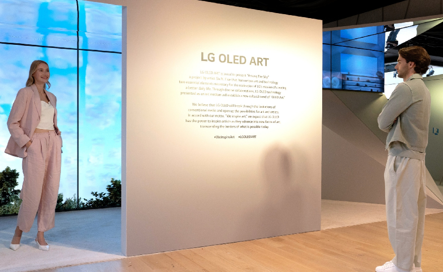 A man and a woman reading a description of the LG OLED Art exhibition on site