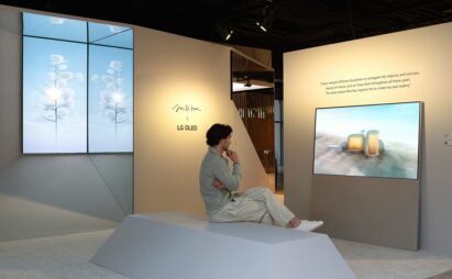 A man sitting cross-legged at the LG OLED Art exhibition while viewing artwork on LG Objet Collection Easel