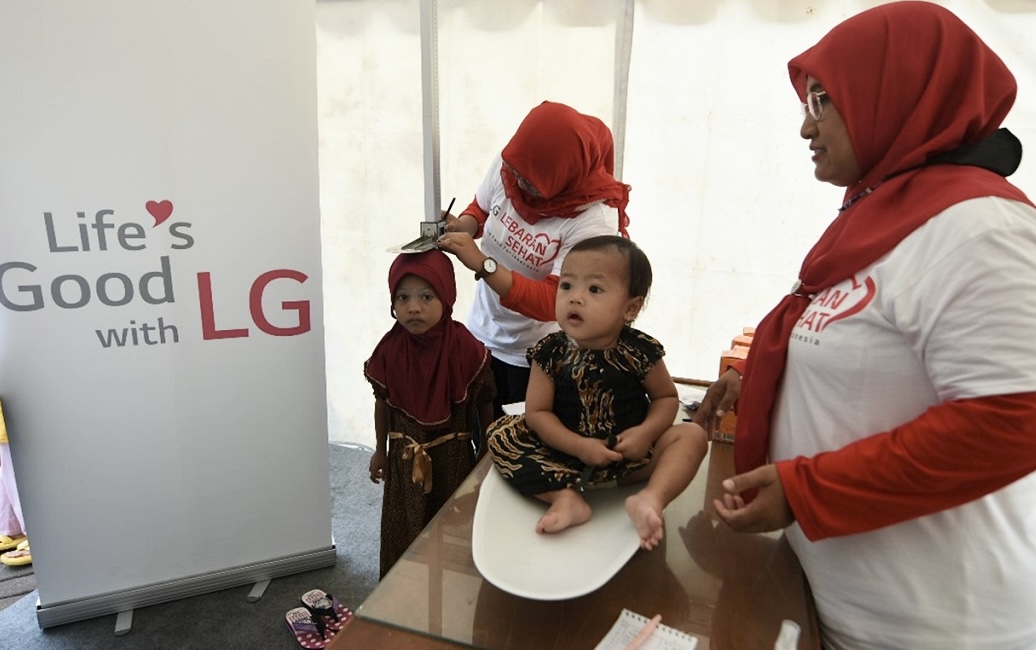 A photo of staff performing a general health checks for children under LG LOVES Indonesia campaign
