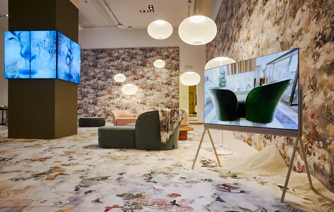 LG OLED Object Collection Posé on display at an exhibition with bright round lights and a variety of lifestyle furniture