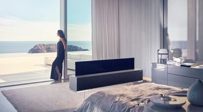 LG SIGNATURE OLED R installed in a luxury room where a woman is leaning against a big window