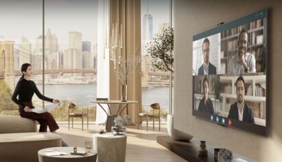 A career woman video conferencing via an expansive LG TV and LG Smart Cam in a room with an amazing New York City skyline view