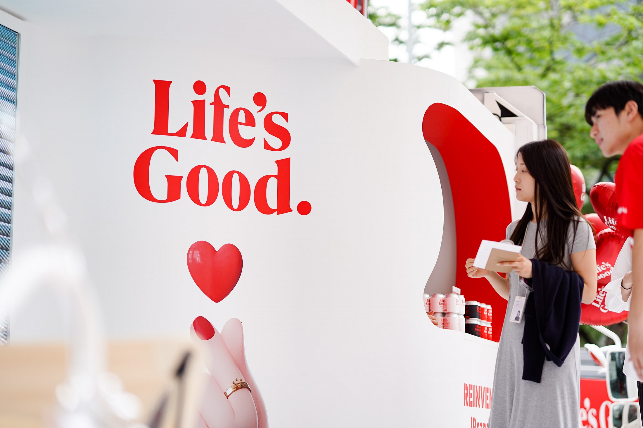 LG employees looking at the Life's Good image printed on the outside of the event truck