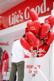A close-up photo of a bunch of red balloons with the phrase 