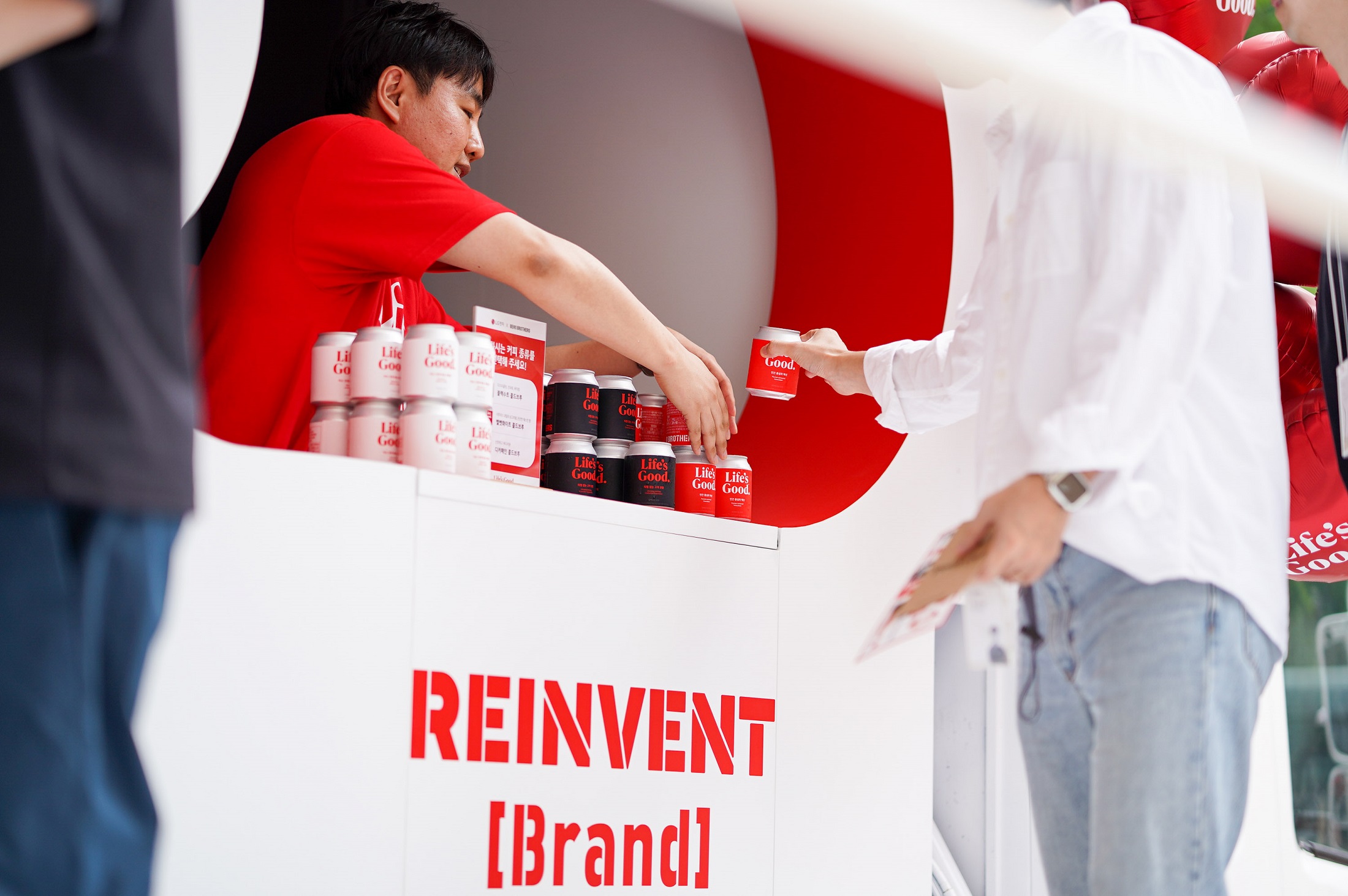 A staff handing out a coffee can to the visitor of the Life's Good event