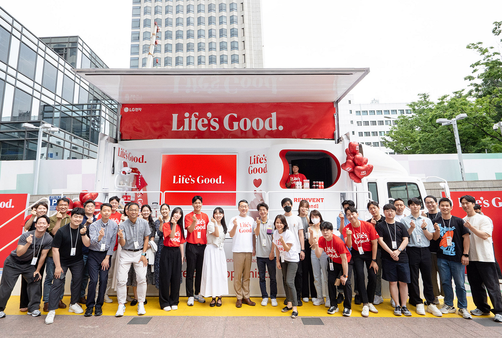 LG CEO and employees posing together for a photo in front to the Life's Good event truck