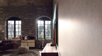 A side view of LG OLED M3 hanging on a living room wall as sunlight pours in from its large windows