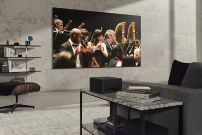 LG SIGNATURE OLED M3 TV mounted on the wall of a gray-themed living room as it displays an orchestra performance