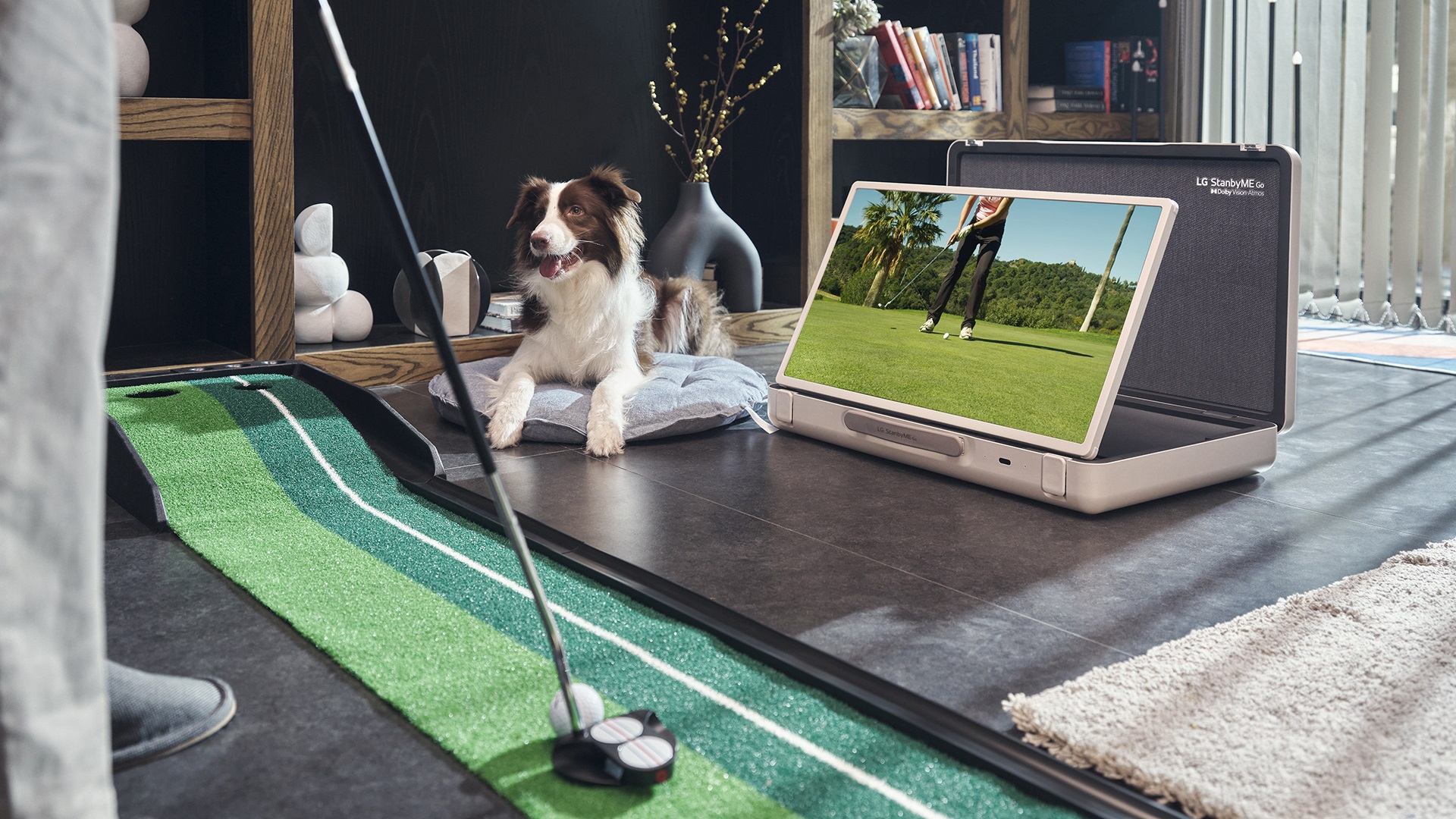 A man putting at home while watching a golf tutorial through LG StanbyME Go’s landscape mode