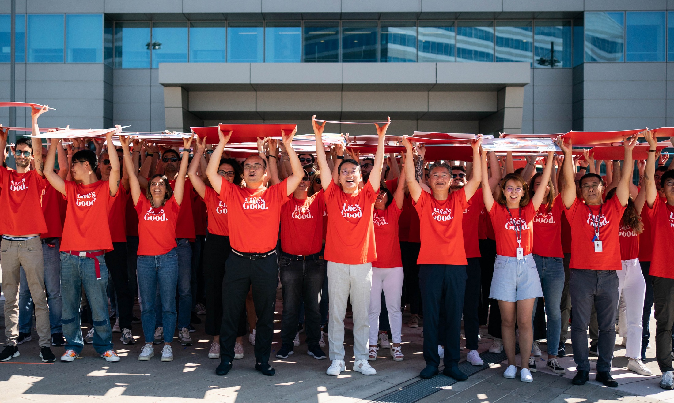 LG CEO Cho and LG Italy employees holding panels which have various lifestlye images