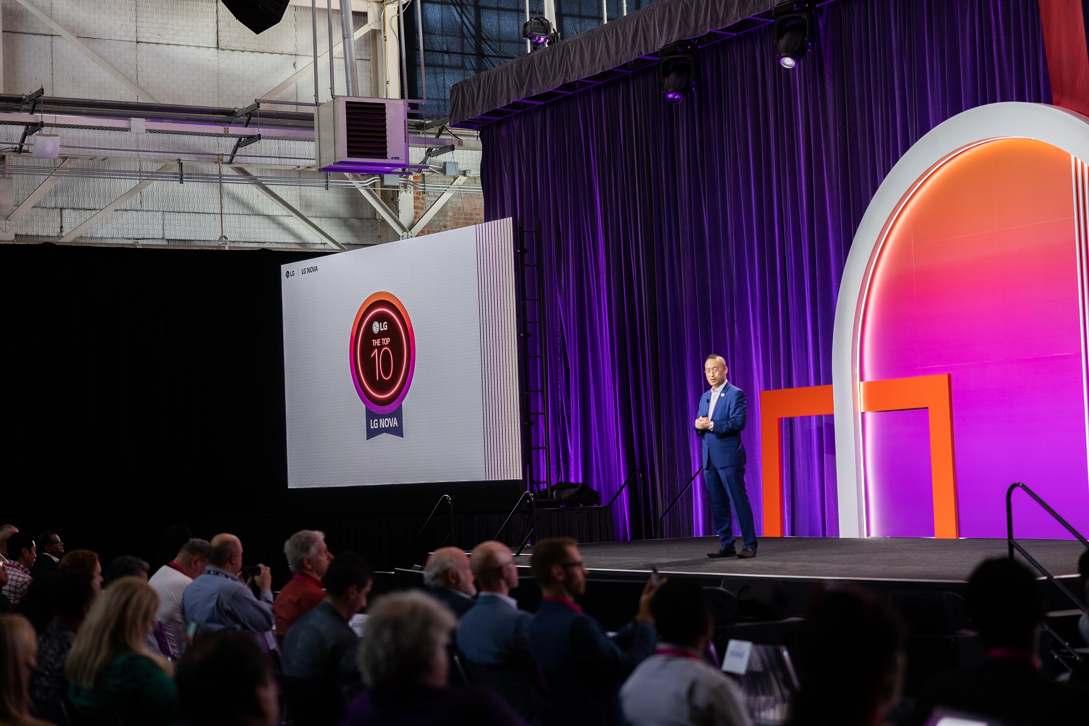 A photo of a LG NOVA event where Sokwoo Rhee is giving a speech