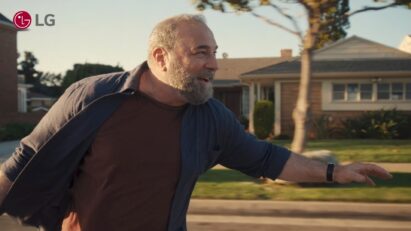 A closeup photo of an old man riding a longboard