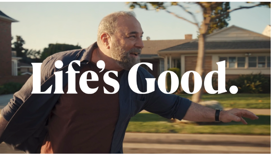 An image of a man riding a longboard with a phrase "Life's Good." overlapping