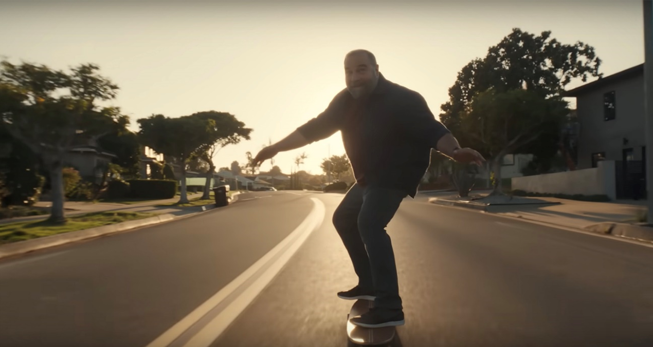 Middle aged man riding a longboard