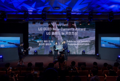 Two filmmakers receiving the LG OLED New Currents Award on the stage of the Busan International Film Festival