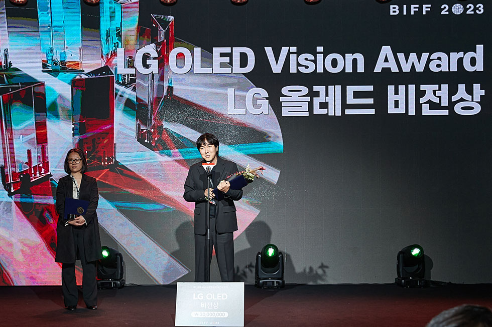 LG OLED Vision Award recipient Director Jeong Beom giving a speech while holding a trophy