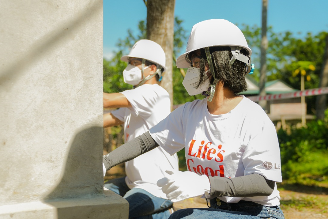 LG Vietnam employees painting a wall to renovate an old house