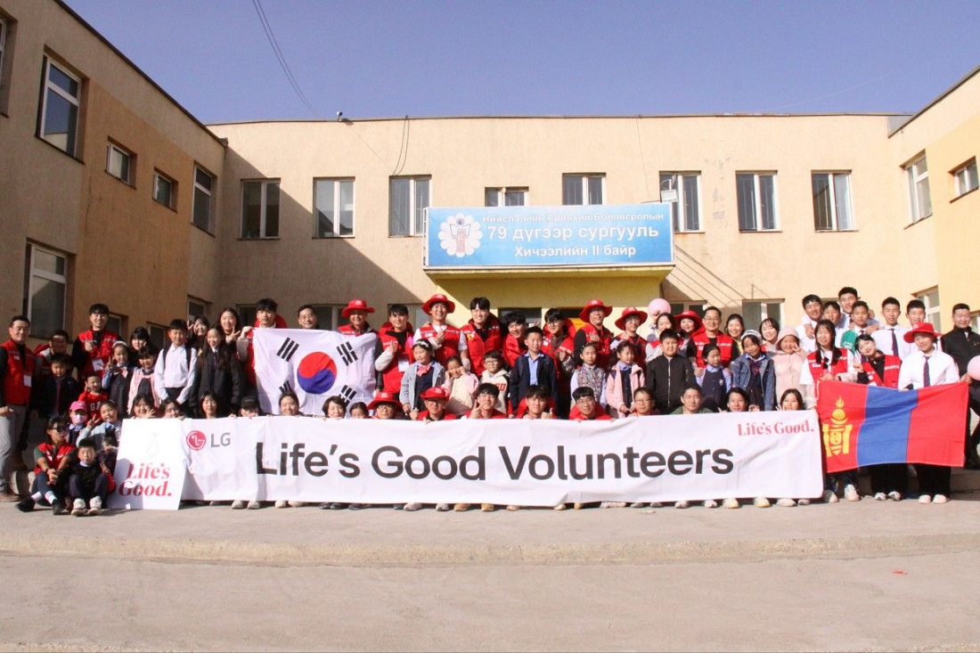 Life's Good Volunteers posing altogether in front of the school