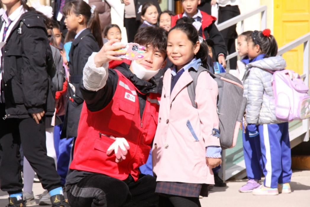 A Life's Good volunteer taking a photo with a young girl