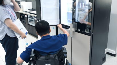 A man is testing the Easy Handle Kit applied to the LG InstaView refrigerator doors, and a woman is standing on the left