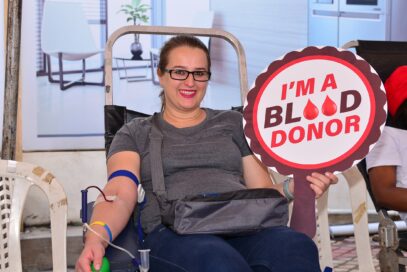 A participant of Life's Good Blood Drive holding a panel that reads, 'I'm a blood donor.'