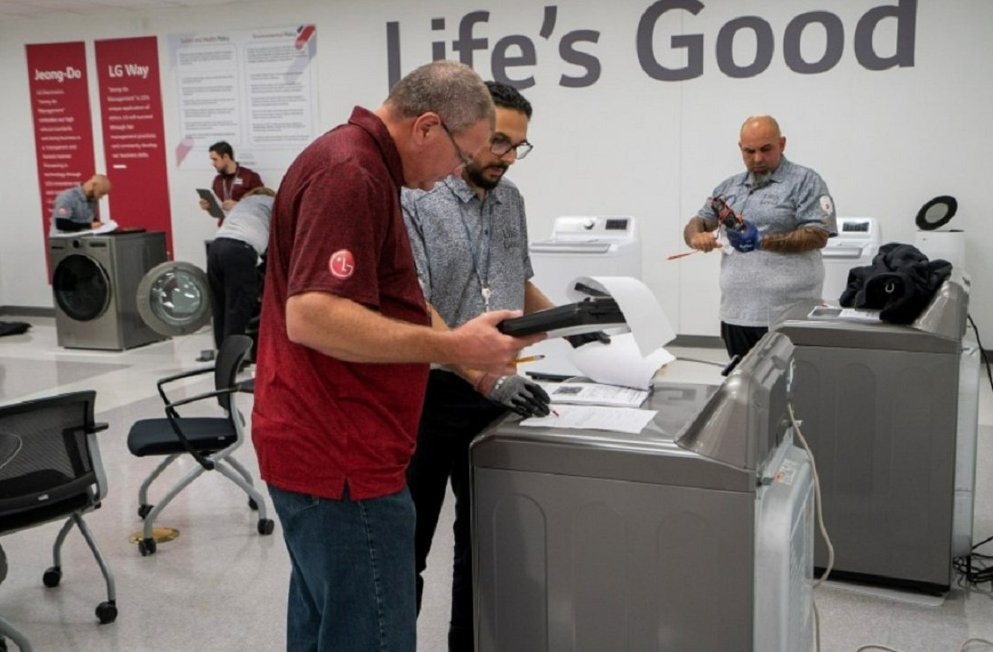 A photo of LG Service Managers gathered around a washer and dryer