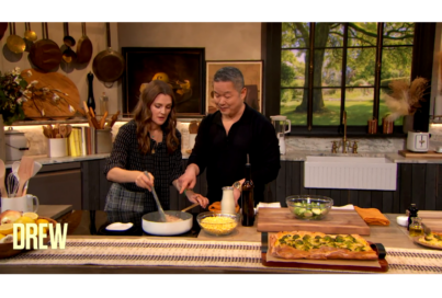 A photo, with white space on the top and bottom, of Drew Barrymore and Danny cooking together
