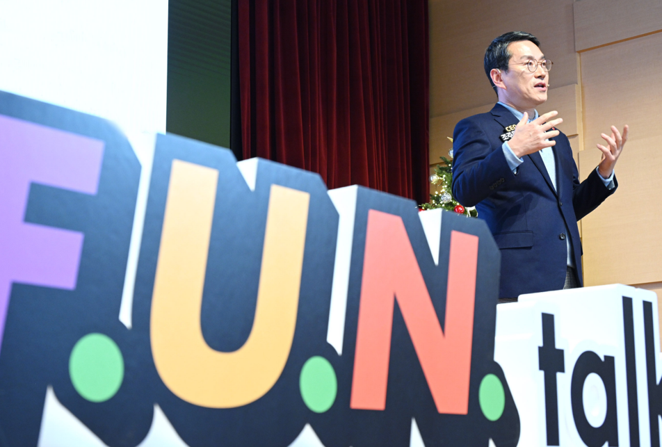 A photo of the LG CEO William Cho talking on stage with a big sign that says 'F.U.N. talk'