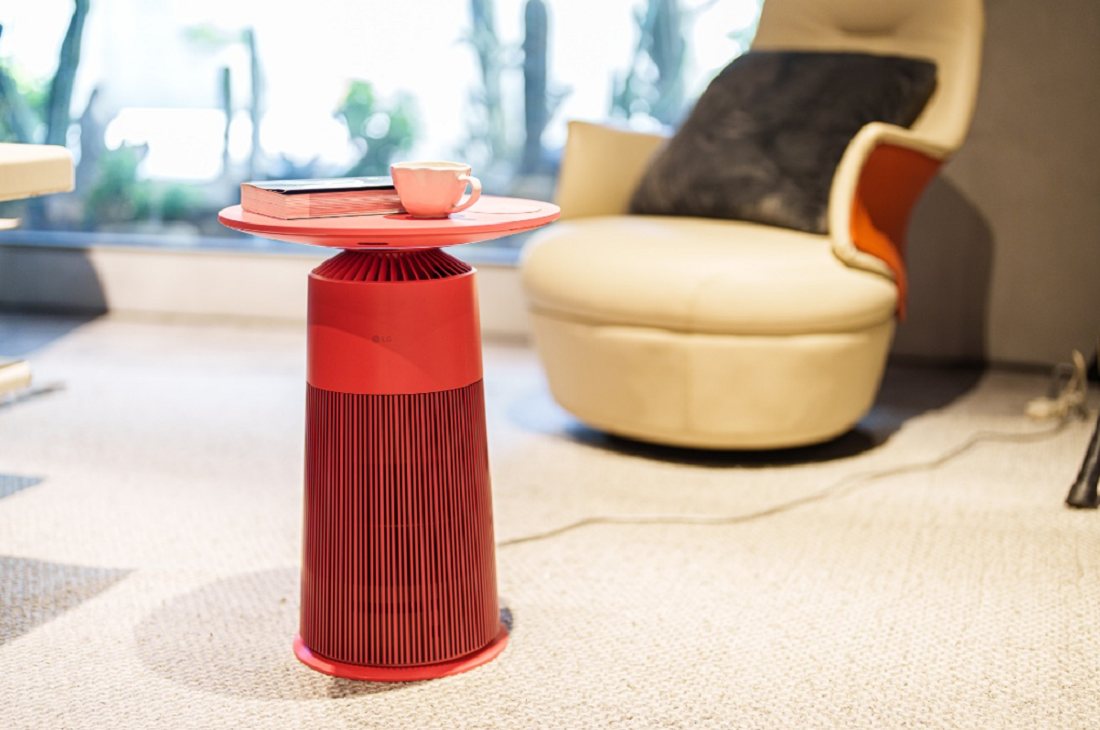 A photo of the LG PuriCare AeroFurniture placed with a book and a cup on top