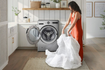 An image of a woman taking the laundry out of the LG WashCombo
