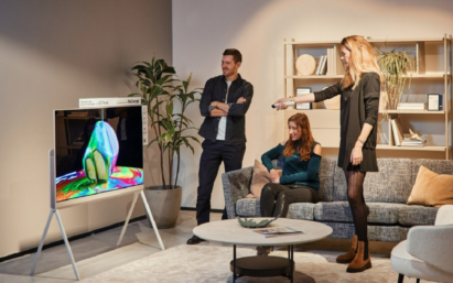 A photo of three people in a living room enjoying the LG Objet Collection Pose