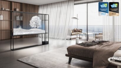 The LG OLED T displays a snowy scene in a bedroom with a bookshelf visible behind the transparent screen