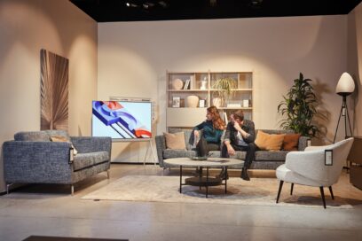 A photo of a man and a woman watching the LG Objet Collection Pose on the couch