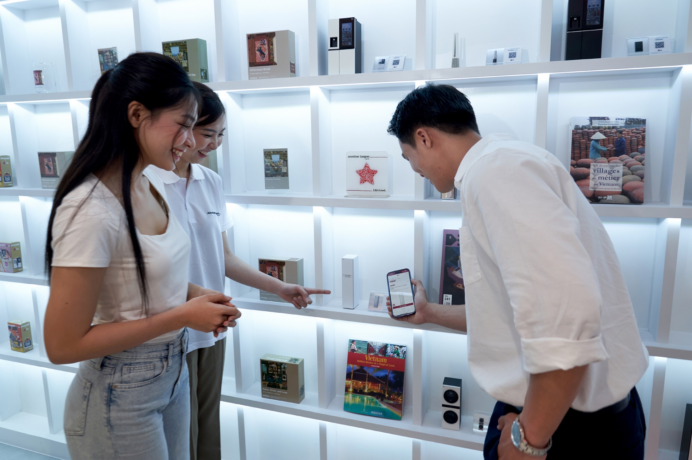 A photo of three people gathered around looking at a mobile screen at the venue