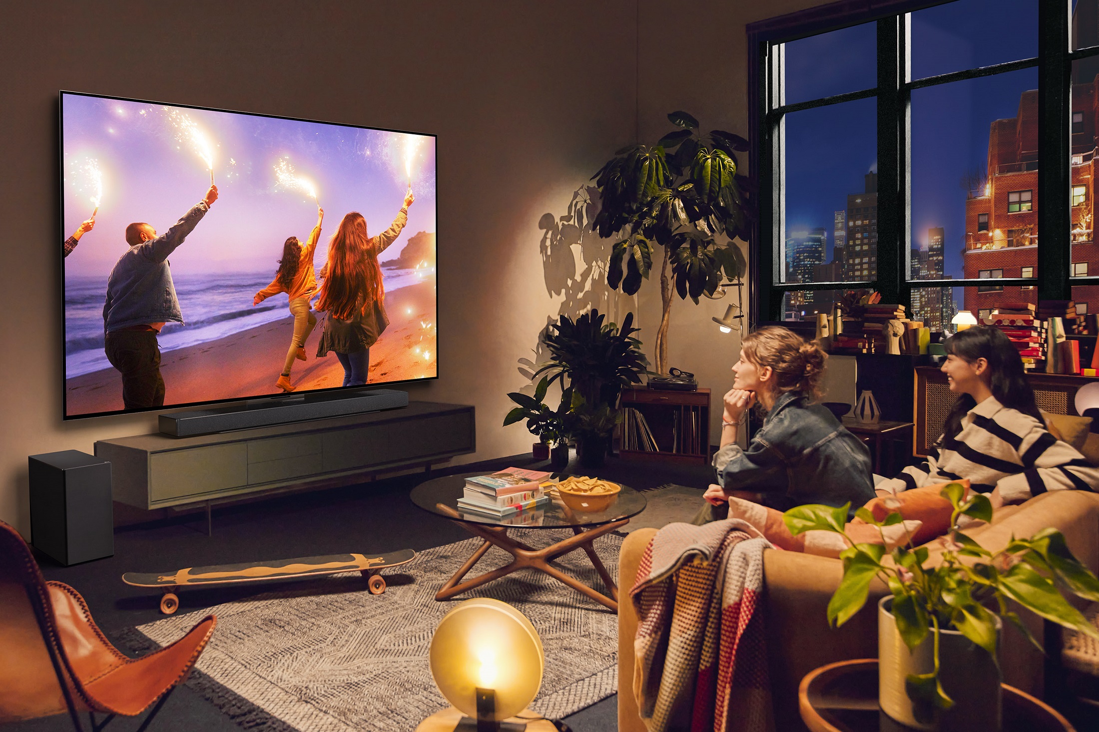 A photo of two women watching television while sitting on a couch