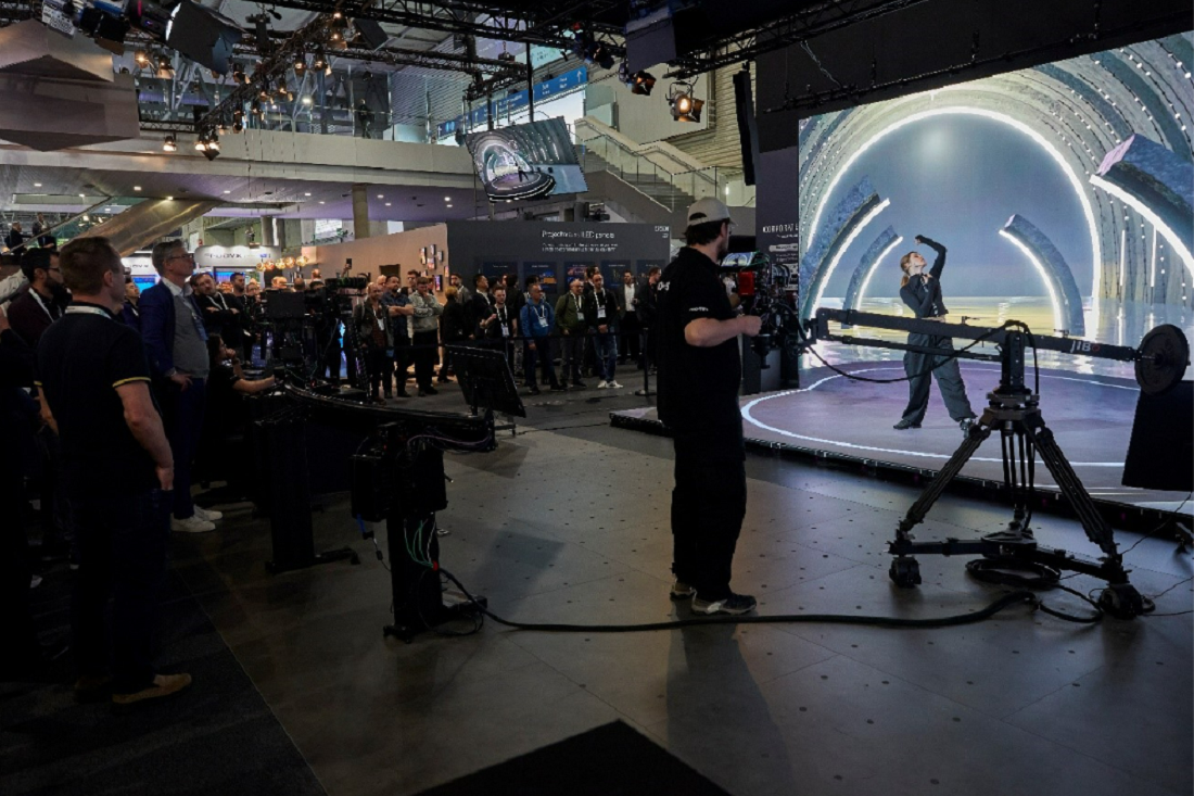 A photo of the filming set of people gathered around filming and watching