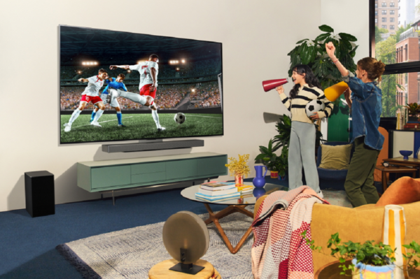 A photo of two women celebrating while watching the television screen